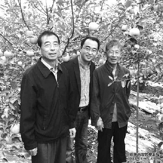 李庆军经常跟果农在一起,讨论苹果种植知识。